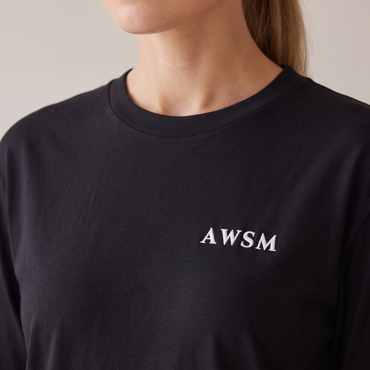 Crépuscule Long Sleeve Tee — AWSM Maison in Onyx Black, close-up of the embroidery on the AWSM house model