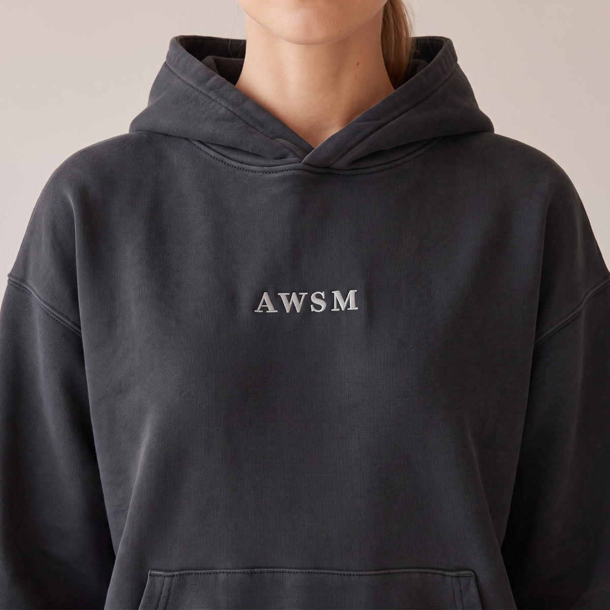 Héritage Vintage Hoodie — AWSM Maison in Volcanic Black, close-up of the embroidery on the AWSM house model