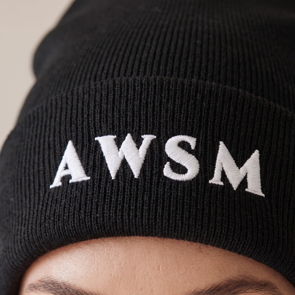 Hiver Cuffed Beanie — AWSM Maison in Onyx Black, close-up of the embroidery on the AWSM house model