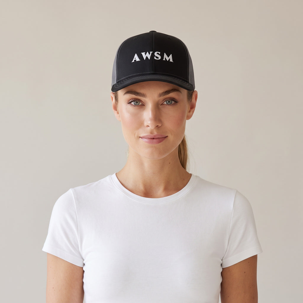 Minuit Trucker Cap — AWSM Maison in Onyx / Graphite, shown on the AWSM house model
