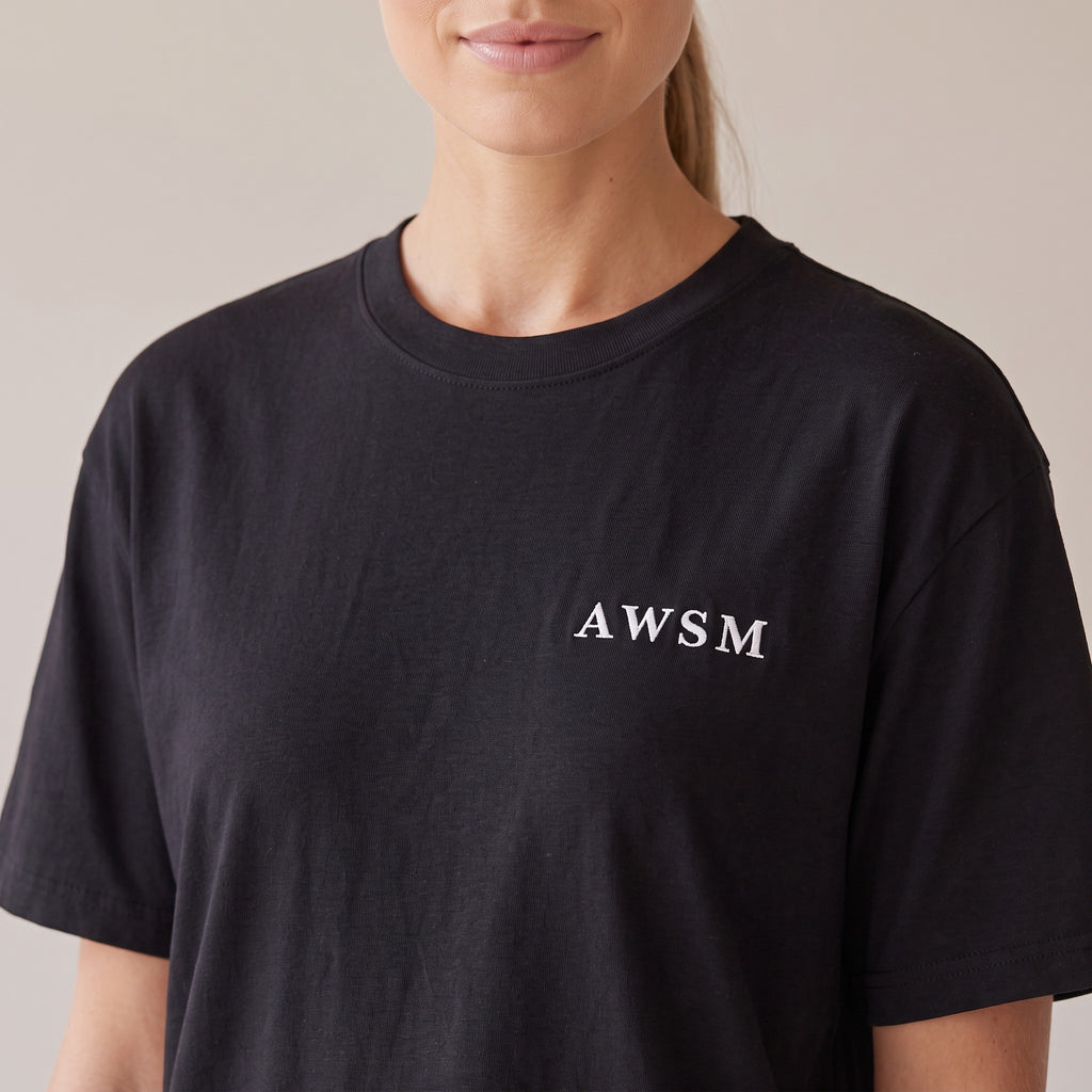 Nocturne Heavyweight Tee — AWSM Maison in Onyx Black, close-up of the embroidery on the AWSM house model