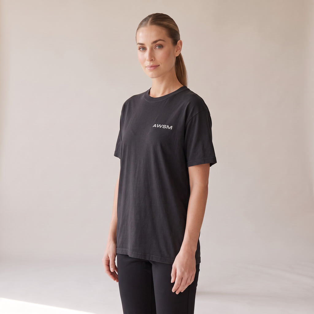 Outpost Heavyweight Tee — AWSM Field in Onyx Black, three-quarter view on the AWSM house model