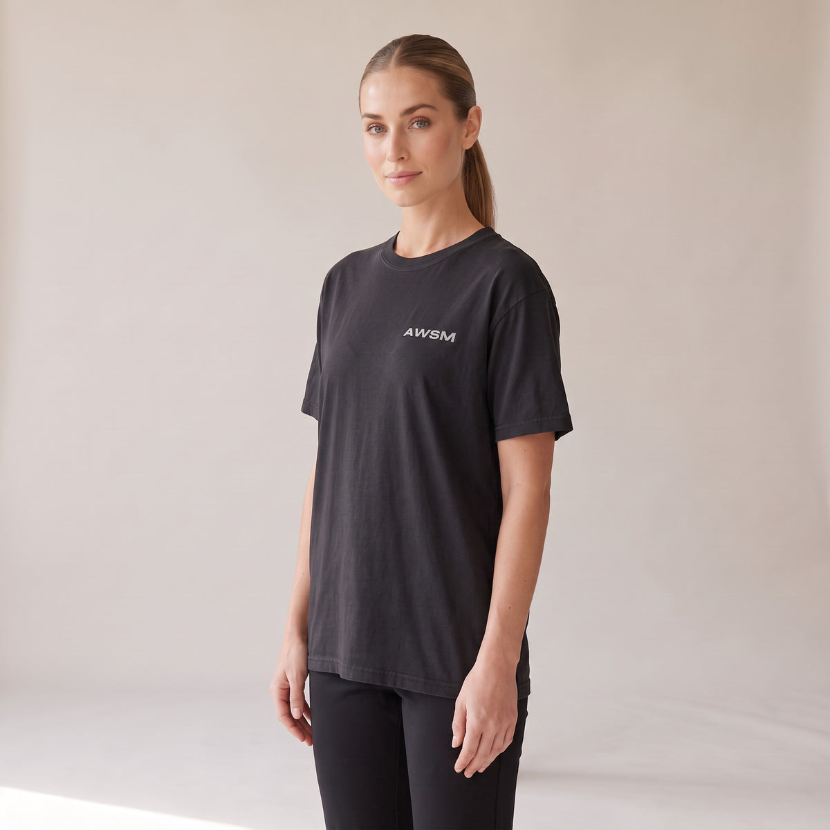 Outpost Heavyweight Tee — AWSM Field in Onyx Black, three-quarter view on the AWSM house model