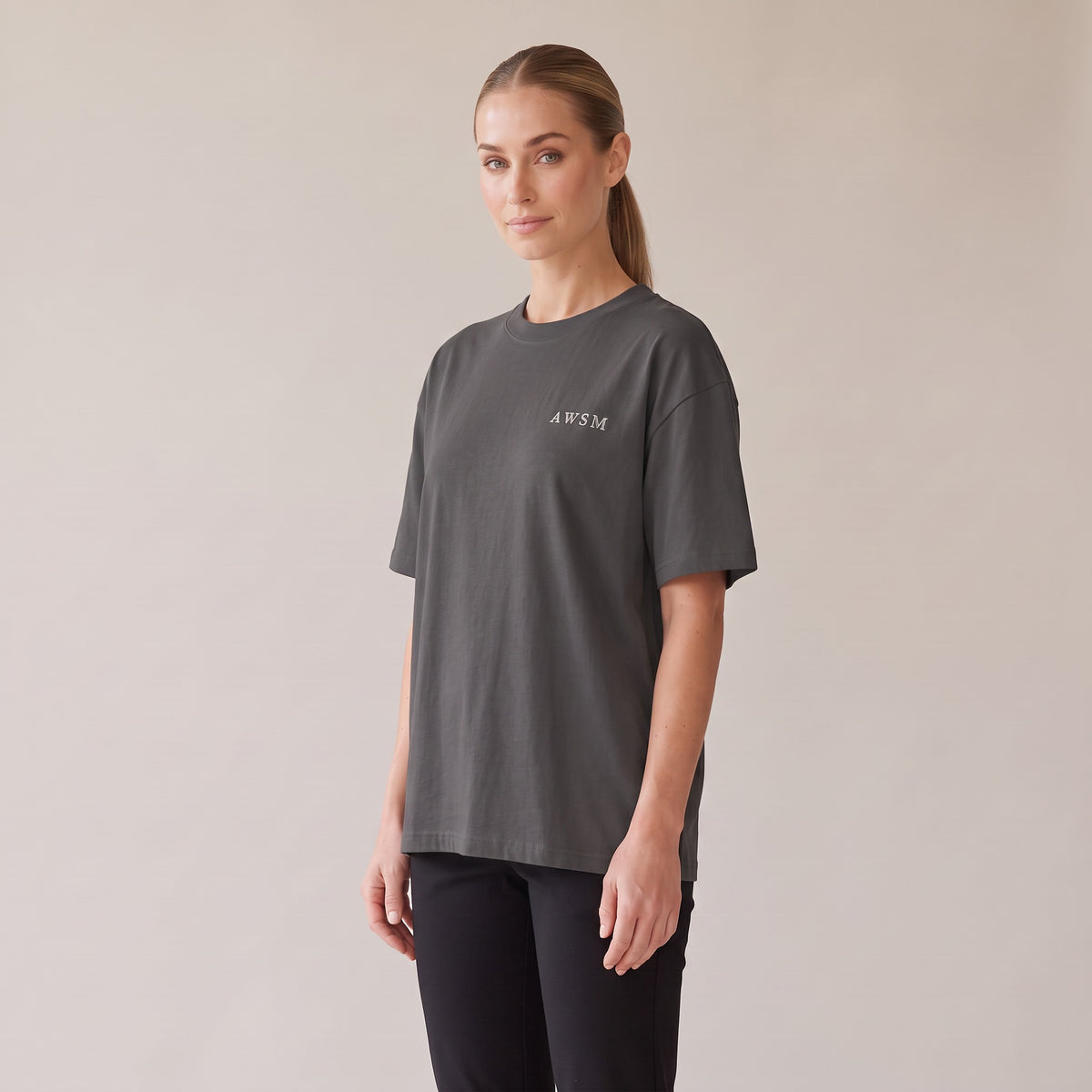 Patina Oversized Tee — AWSM Maison in Faded Onyx, three-quarter view on the AWSM house model