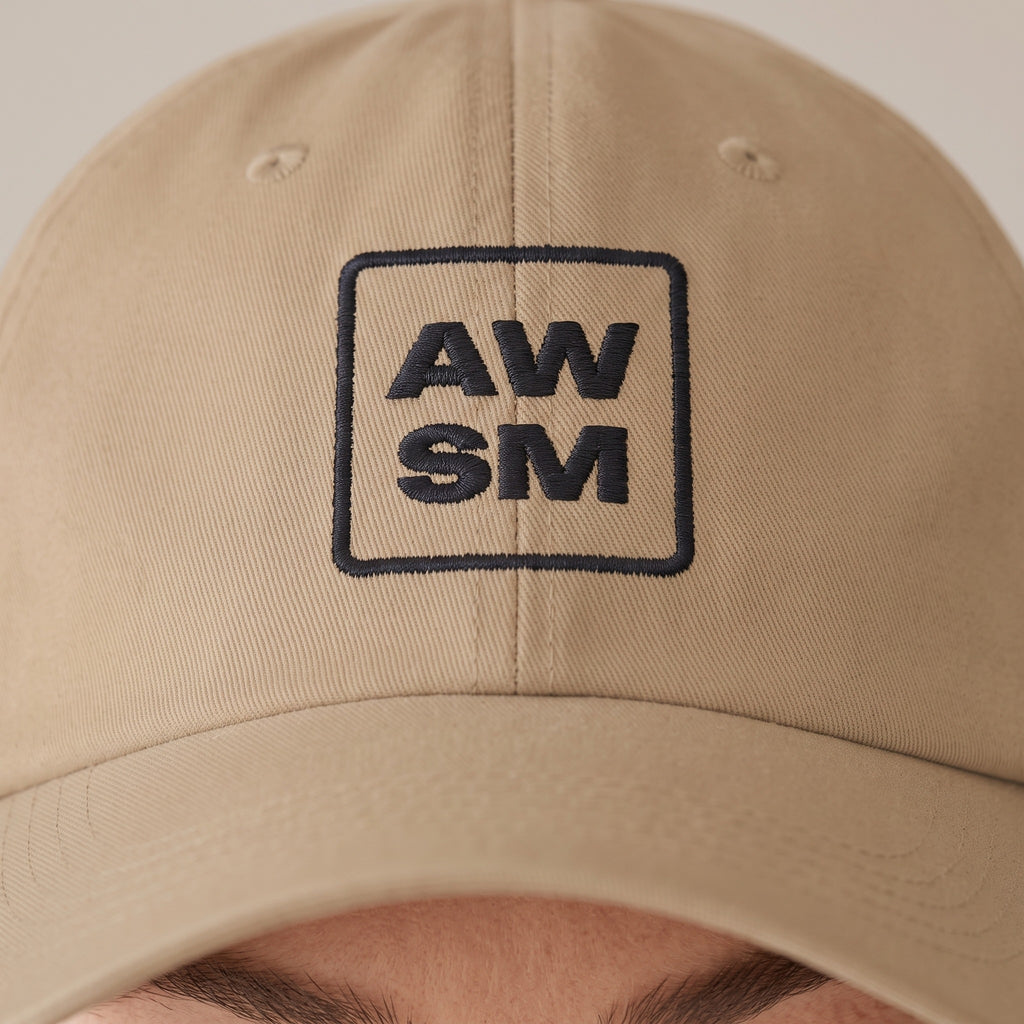 Plâtre Dad Hat — AWSM Atelier in Sahara Khaki, close-up of the embroidery on the AWSM house model