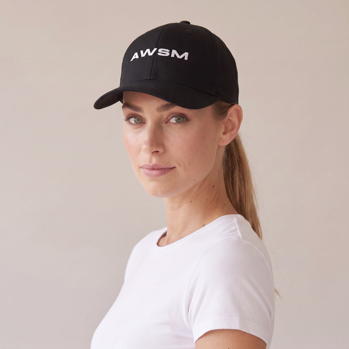 Recon Structured Cap — AWSM Field in Onyx Black, three-quarter view on the AWSM house model