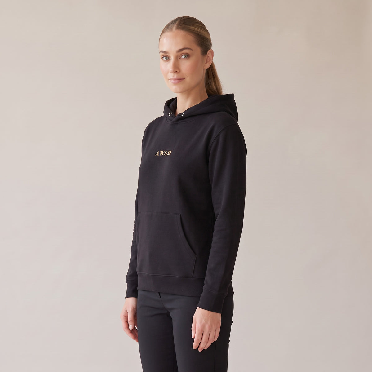 Regalia Hoodie — AWSM Aurum in Onyx Black, three-quarter view on the AWSM house model