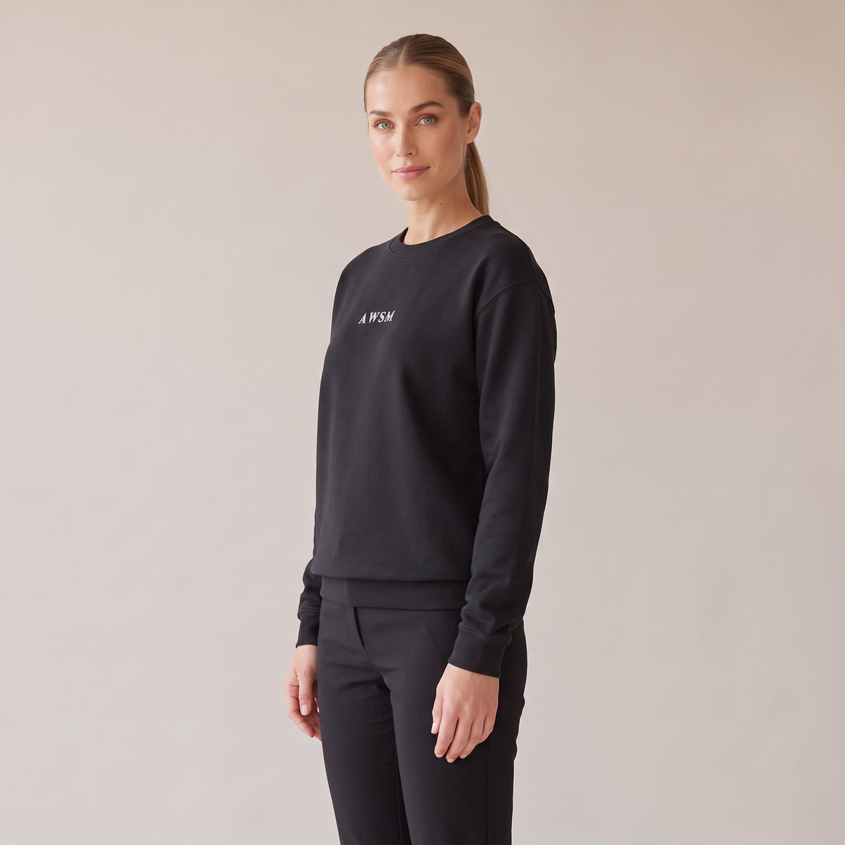 Salon Crewneck — AWSM Maison in Onyx Black, three-quarter view on the AWSM house model
