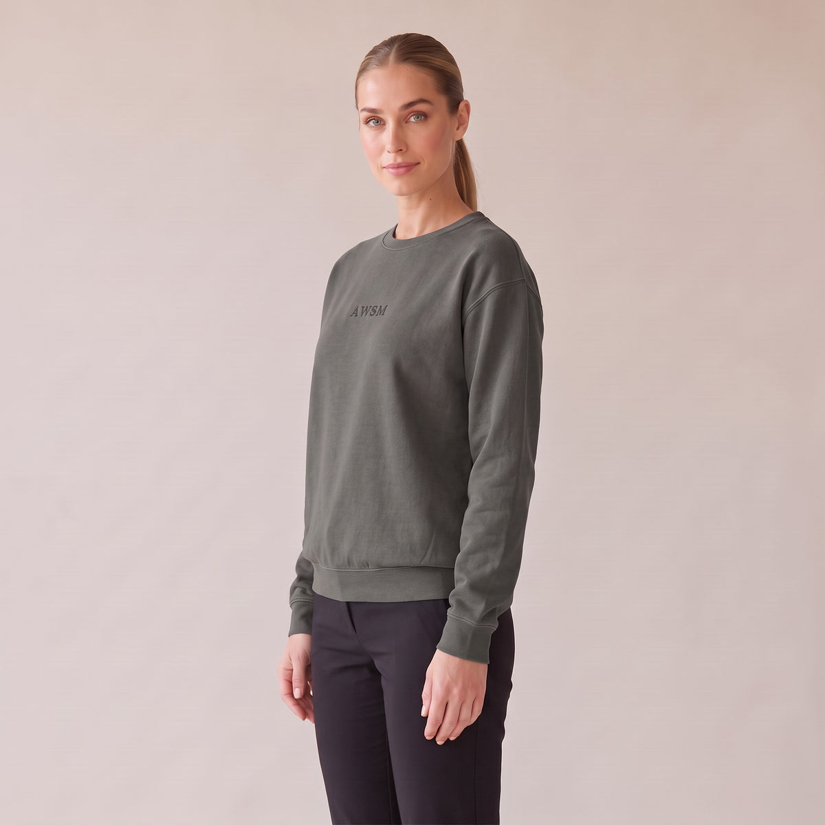 Salon Crewneck — AWSM Maison in Peppercorn Grey, three-quarter view on the AWSM house model