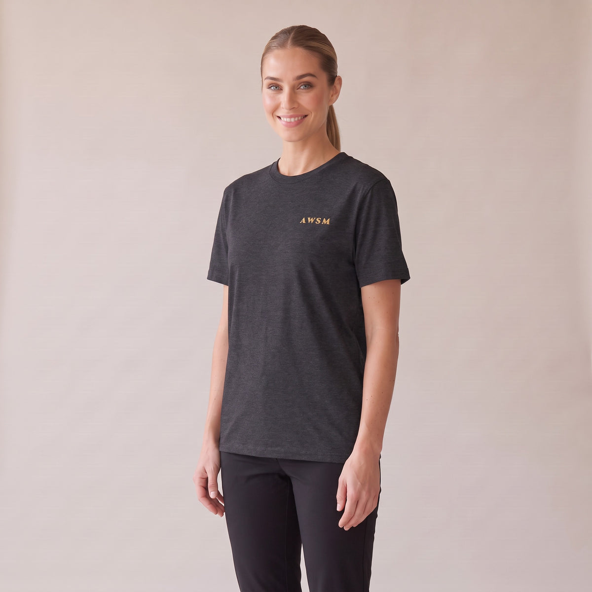 Sovereign Heavyweight Tee — AWSM Aurum in Charcoal Heather, three-quarter view on the AWSM house model