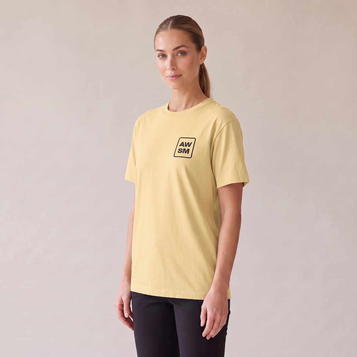 Studio Heavyweight Tee — AWSM Atelier in Butter Cream, three-quarter view on the AWSM house model