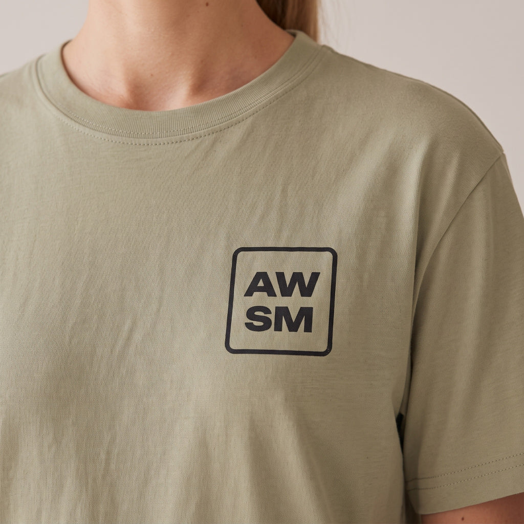Studio Heavyweight Tee — AWSM Atelier in Sahara Khaki, close-up of the embroidery on the AWSM house model