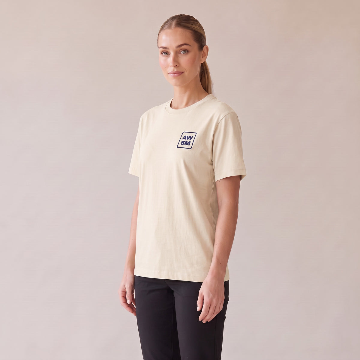 Terre Organic Tee — AWSM Atelier in Raw Natural, three-quarter view on the AWSM house model