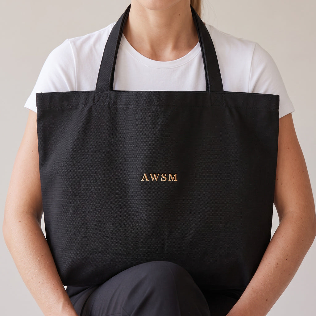 Trésor Twill Tote — AWSM Aurum in Onyx Black, close-up of the embroidery on the AWSM house model
