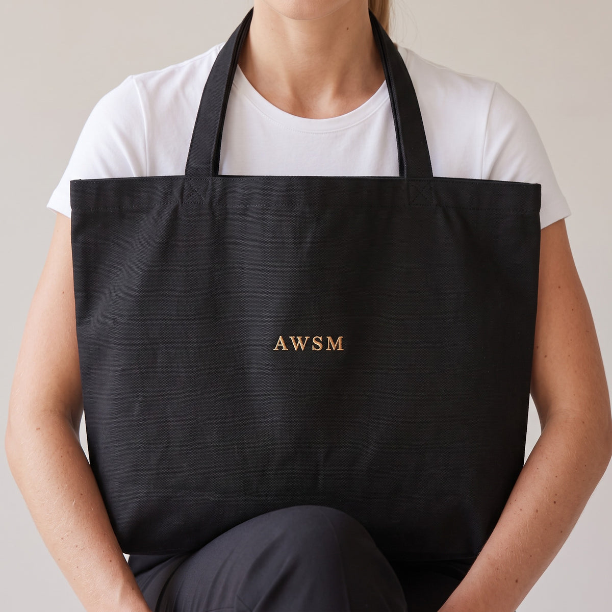 Trésor Twill Tote — AWSM Aurum in Onyx Black, close-up of the embroidery on the AWSM house model