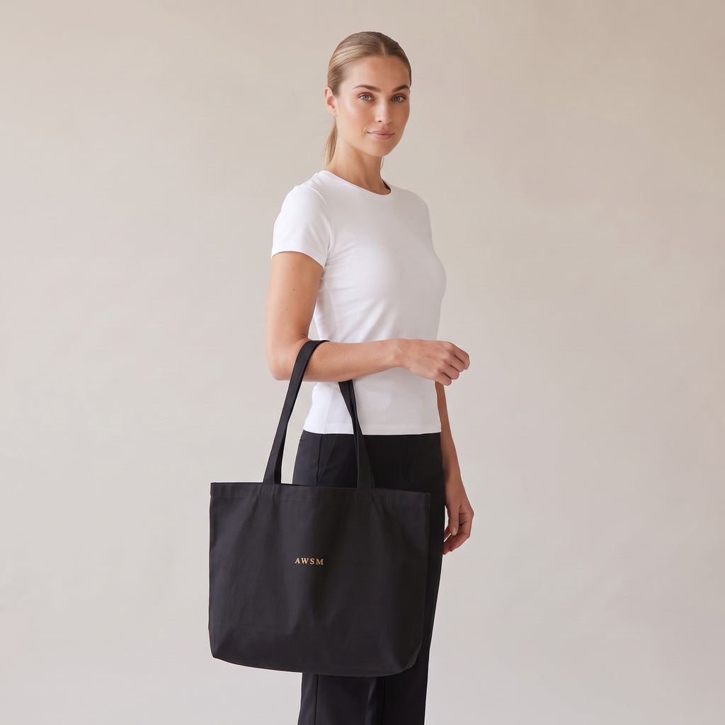 Trésor Twill Tote — AWSM Aurum in Onyx Black, three-quarter view on the AWSM house model