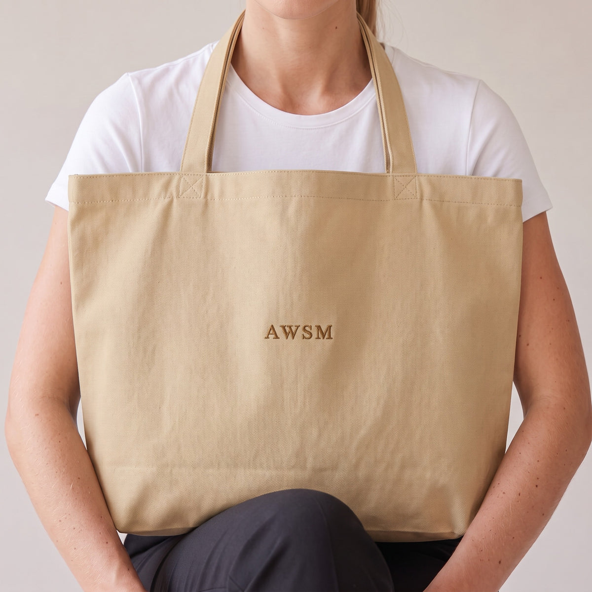 Trésor Twill Tote — AWSM Aurum in Oyster Cream, close-up of the embroidery on the AWSM house model