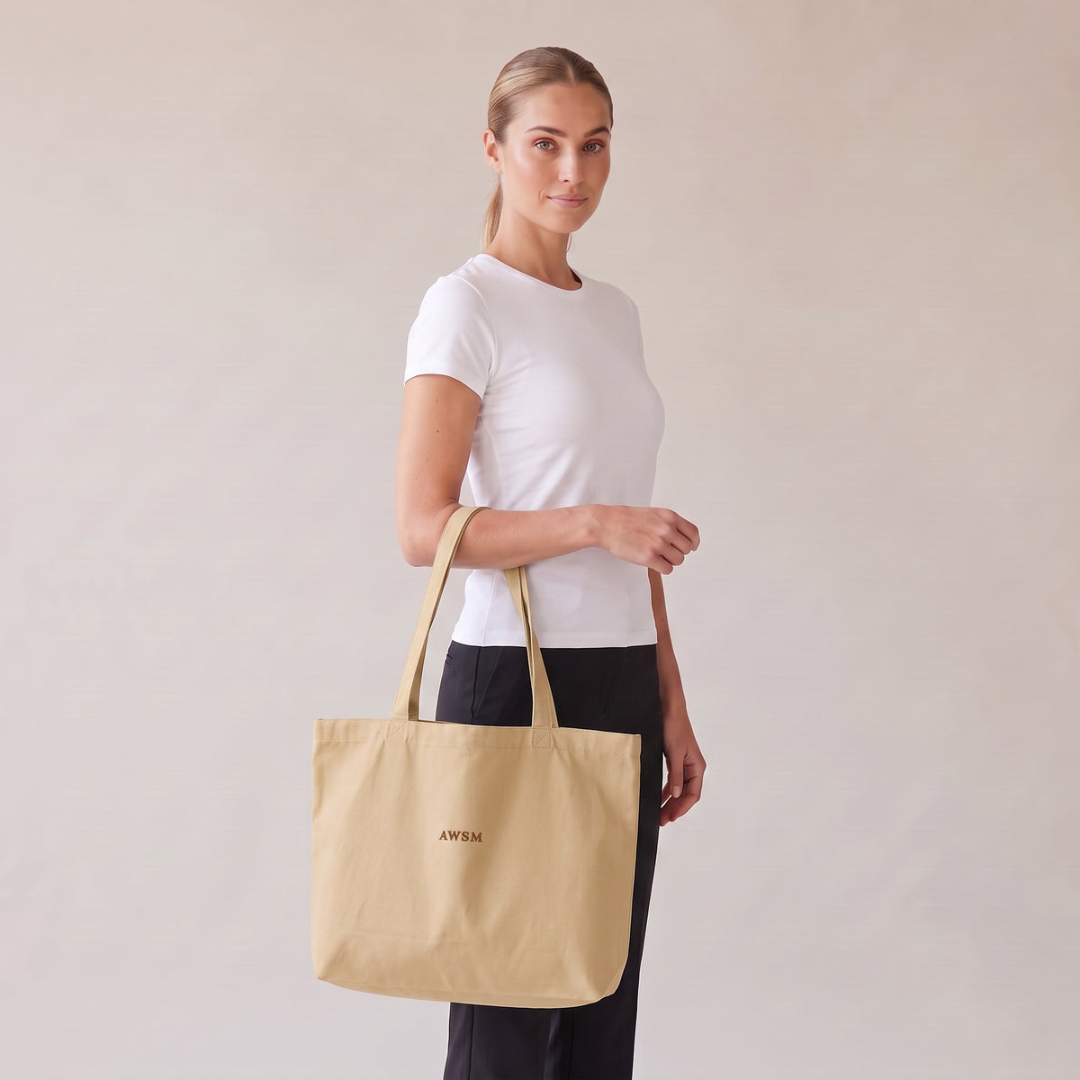 Trésor Twill Tote — AWSM Aurum in Oyster Cream, three-quarter view on the AWSM house model