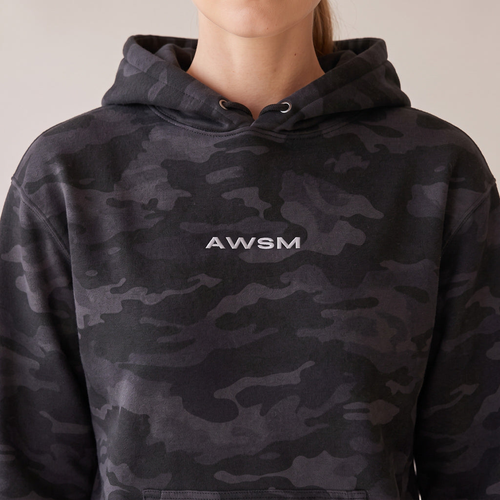 Vanguard Heavyweight Hoodie — AWSM Field in Night Camo, close-up of the embroidery on the AWSM house model