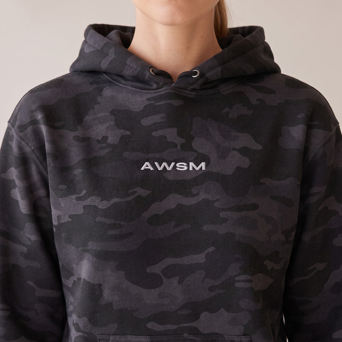 Vanguard Heavyweight Hoodie — AWSM Field in Night Camo, close-up of the embroidery on the AWSM house model