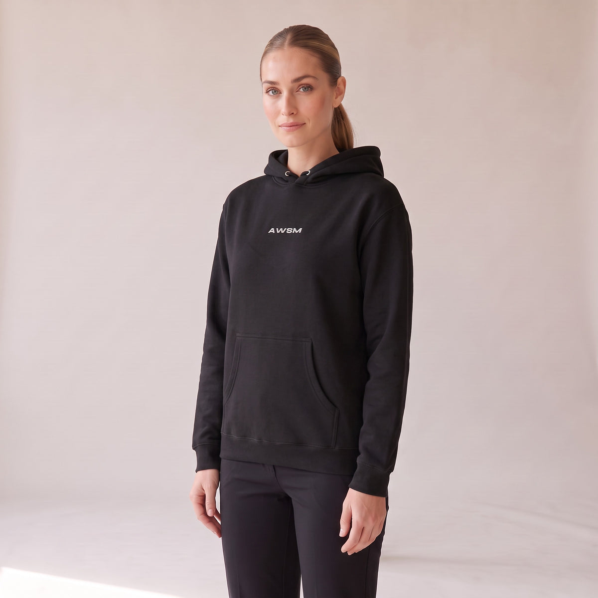 Vanguard Heavyweight Hoodie — AWSM Field in Onyx Black, three-quarter view on the AWSM house model